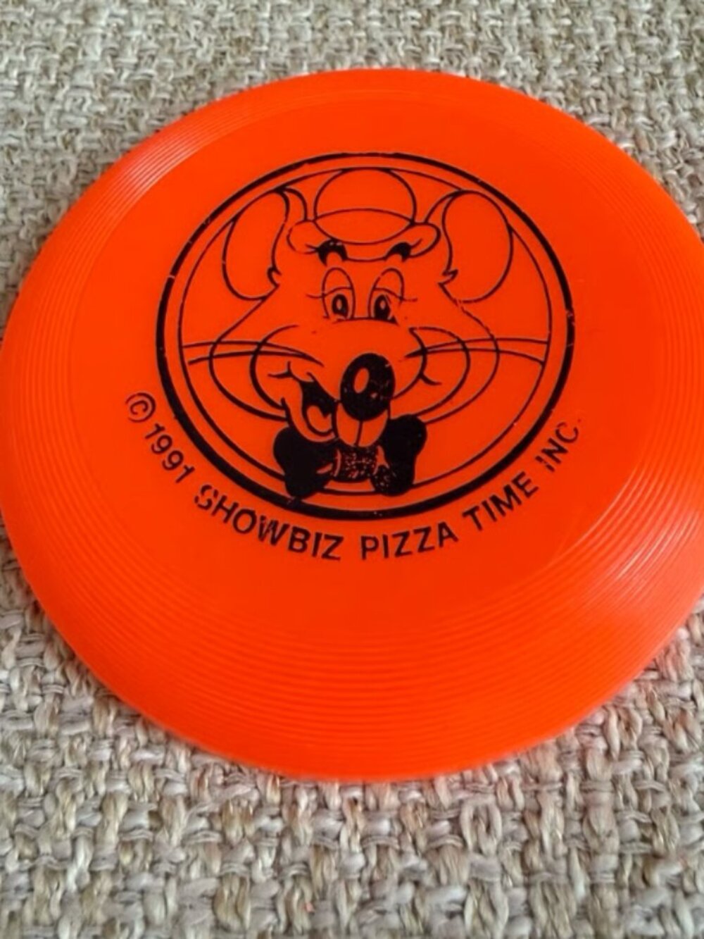 Vintage Chuck E. Cheese collectible mini flying frisbee prize from 1991 orange